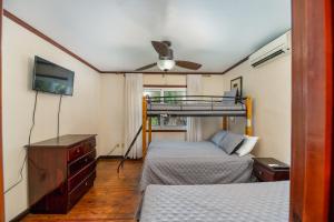 una camera da letto con due letti e un ventilatore a soffitto di Exclusive Full House near Beaches & Downtown a Roatán