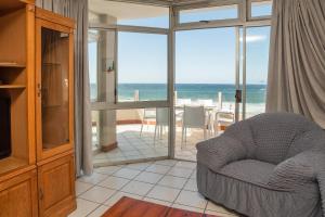 - un salon avec une chaise et une vue sur l'océan dans l'établissement LA CRETE SANDS NO 6, à Margate