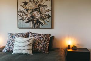 1 cama con 2 almohadas y una pintura en la pared en Rivers Edge Retreat en Orford