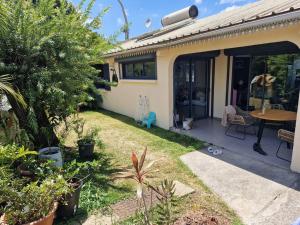 a house with a yard with a table and some plants at Villa avec piscine au centre de la rivière in Saint-Louis