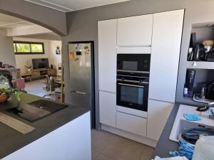 a kitchen with a refrigerator and a stove top oven at Villa avec piscine au centre de la rivière in Saint-Louis