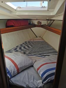 - un lit superposé avec 2 oreillers sur un bateau dans l'établissement stlocavoile 2, Seuls à bord d un voilier, à Porto-Vecchio