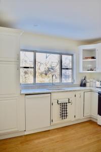 una cucina bianca con lavandino e finestra di Family Friendly Montclair Hideaway a Montclair