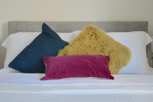 un mucchio di cuscini poggiati sopra un letto di Family Friendly Montclair Hideaway a Montclair