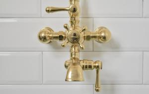 un rubinetto della doccia dorata in bagno di Family Friendly Montclair Hideaway a Montclair