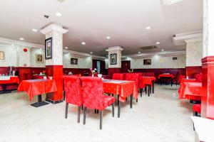 czerwona jadalnia z czerwonymi stołami i krzesłami w obiekcie OYO 492 Gulf Star w Dubaju