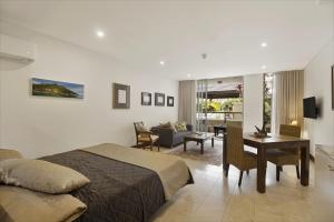 una camera con letto e sala da pranzo di 119 Santai Resort - Poolside Apartment by uHoliday a Casuarina
