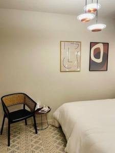 a bedroom with a bed and a chair and a table at 1204 ブランシエラ那覇曙プレミスト in Nakanishi