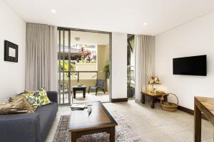 ein Wohnzimmer mit Sofa und Fernseher in der Unterkunft 119 Santai Resort - Poolside Apartment by uHoliday in Casuarina + 6 Fotos