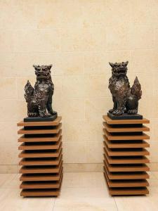 duas estátuas de gatos sentados em cima de blocos em 1204 ブランシエラ那覇曙プレミスト em Nakanishi