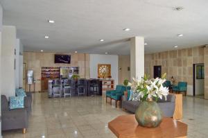 a lobby with couches and a vase of flowers on a table at Hotel del Alba Inn & Suites in Aguascalientes