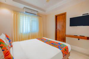 a bedroom with a bed and a flat screen tv at FabHotel Phoenix Brookfield - Nr Kundalahalli Main Road in Bengaluru +25 photos