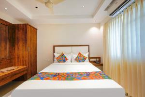 1 dormitorio con 1 cama grande y armario de madera en FabHotel Phoenix Brookfield, en Bangalore