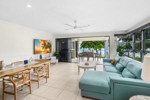 a living room with a blue couch and a table at Sea Point on Trinity Beach in Trinity Beach