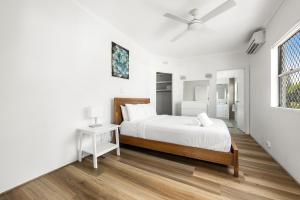a white bedroom with a bed and a window at Central Motel Mooloolaba and Apartments in Mooloolaba