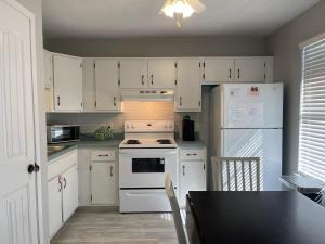 a kitchen with white cabinets and a white stove and refrigerator at Ocean Breeze - Beautiful Condo & Pet Friendly in Gulf Shores