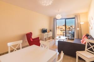 een woonkamer met een bank en een tafel en stoelen bij 2114-Apt with nice terrace with pool view in Manilva