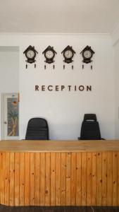 a reception desk with clocks on the wall at Palm Rest Maldives in Magoodhoo