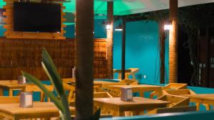 an empty restaurant with wooden tables and a flat screen tv at Palm Rest Maldives in Magoodhoo