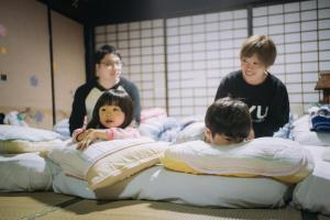 un grupo de niños jugando en las camas en una habitación en Stay and Discover Nishinoya, en Senboku