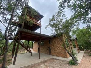 una casa en el árbol con una escalera en la parte superior en Sonador Bush House, en Marloth Park