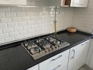 a stove top oven in a kitchen with white tiles at Marsa Central Splendid Appart 2 in La Marsa