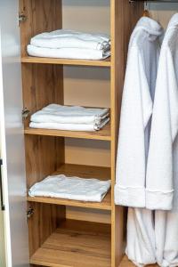 a wooden closet with white towels in it at Готель «На Кронштадській» in Avtozavodskiy Rayon