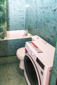 a bathroom with a washing machine in front of a toilet at Готель «На Кронштадській» in Avtozavodskiy Rayon