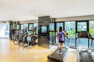 une femme qui marche sur un tapis de course dans une salle de sport dans l'établissement Central Pattaya Condo Best Pool & Great Location, à Pattaya