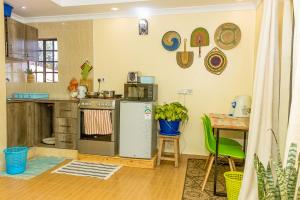 a kitchen with a stove and a table with a tableablish at Kenai Stay, Secluded 1 bedroom with free parking in Nanyuki +2 photos