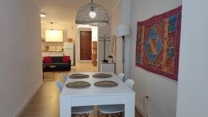 ein weißes Esszimmer mit einem weißen Tisch und Stühlen in der Unterkunft Céntrico Apartamento en Ronda in Ronda