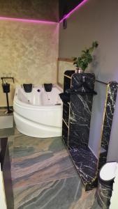 a bathroom with a white bath tub and a plant at Fantasy Room in Lupeni
