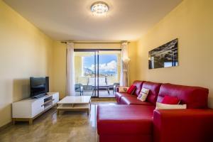マニルバにある2134-Modern apt with terrace sea viewのリビングルーム(赤いソファ、テレビ付)