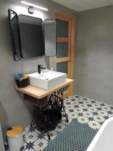 ein Bad mit einem Waschbecken und einem Spiegel in der Unterkunft Le 28 in Uzerche
