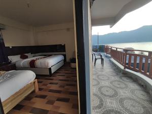 a bedroom with two beds and a balcony with the ocean at Hotel Kajiinn in Pokhara
