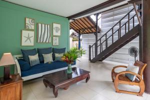 a living room with a blue couch and a table at Villa Coco Bali in Seminyak