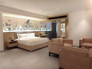 sypialnia z łóżkiem, kanapą i krzesłami w obiekcie Signature Hotels w mieście Visakhapatnam