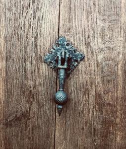 um batedor de porta de metal numa porta de madeira em Le Clos de la Tour 