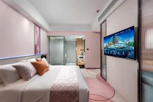 a bedroom with a large bed and a flat screen tv at Jinshi Hotel in Guangzhou