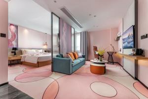 um quarto de hotel com uma cama e um sofá em Jinshi Hotel em Guangzhou