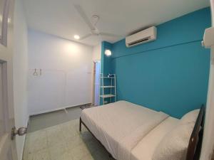 a room with a bed and a blue wall at Go Homestay @ Kuala Kubu Bharu 