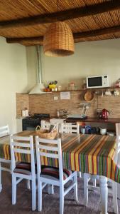 eine Küche mit einem Tisch mit Stühlen und einem Herd in der Unterkunft El Campito de La Ciénaga de Huaco in Huaco