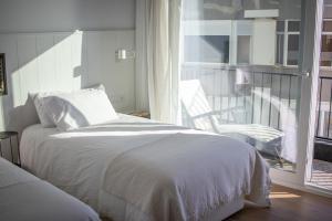 een slaapkamer met een bed en een balkon met een stoel bij Apartamento sobre el rio Guadiana in Ayamonte