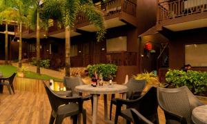 einen Tisch und Stühle in einem Restaurant mit Palmen in der Unterkunft La Gracia Resort in Morjim