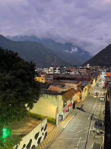 vistas a una ciudad con montañas en el fondo en Tiny apartment in the city rooftop terrace, en Baños