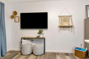 a living room with two chairs and a tv on the wall at Beach View & SeaBreezes in Corpus Christi