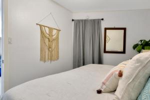 Un dormitorio con una cama blanca y un espejo. en Beach View & SeaBreezes, en Corpus Christi