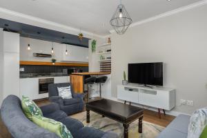 - un salon avec un canapé et une télévision dans l'établissement Buitenhof 301, au Cap