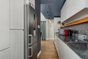 una cucina con armadietti bianchi ed elettrodomestici in acciaio inossidabile di Buitenhof 301 a Città del Capo