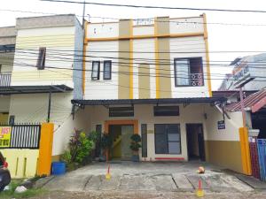 un bâtiment jaune et blanc avec orange dans l'établissement OYO 92231 Penginapan Tanjung Alang Syariah, à Makassar